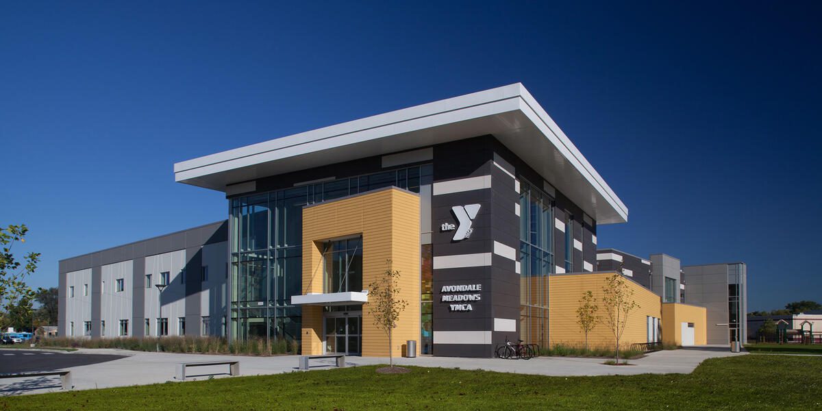 Modern YMCA building with clear blue sky background.